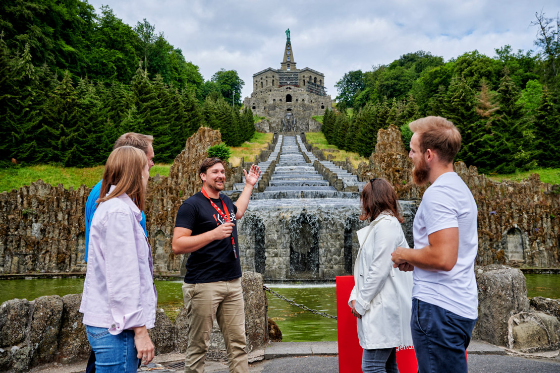 Two couples can be explained about the water features at the foot of the cascades during a guided tour